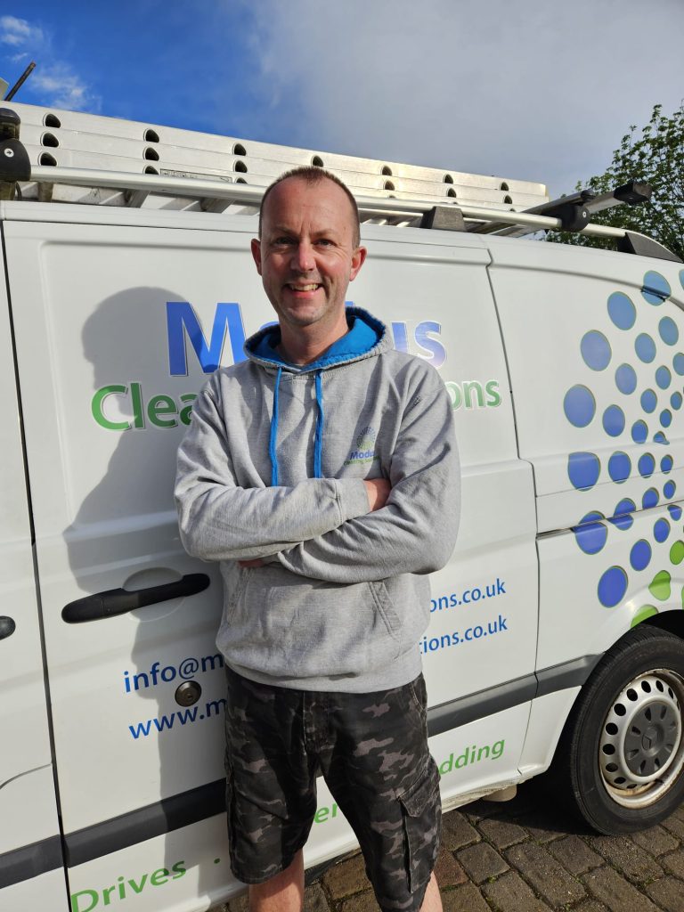 image is of Steven the owner of Modus standing next to his van